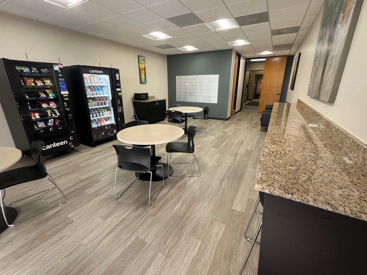 Tenant break room with cafe seating, vending, and mail center