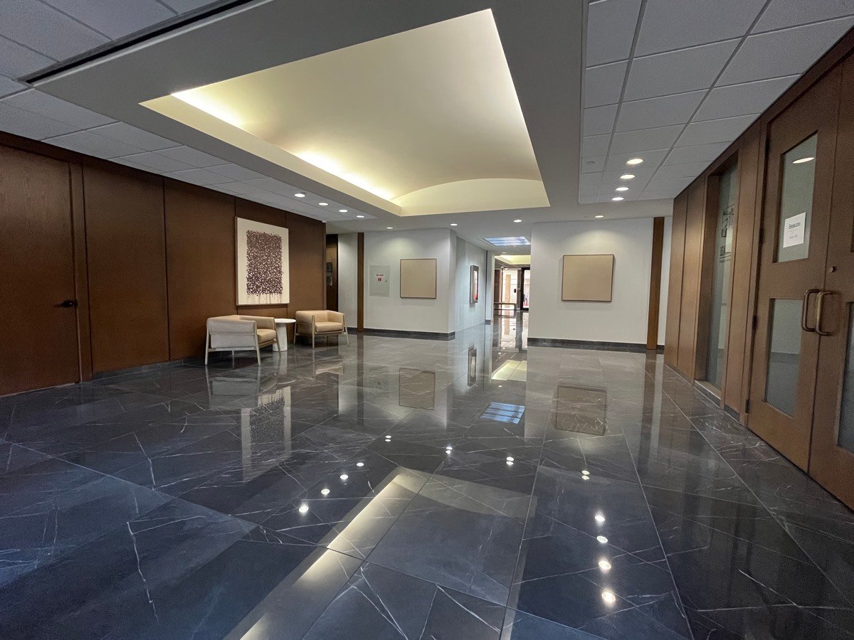 Main lobby at 1800 Saint James Place with polished marble floors and walnut paneling